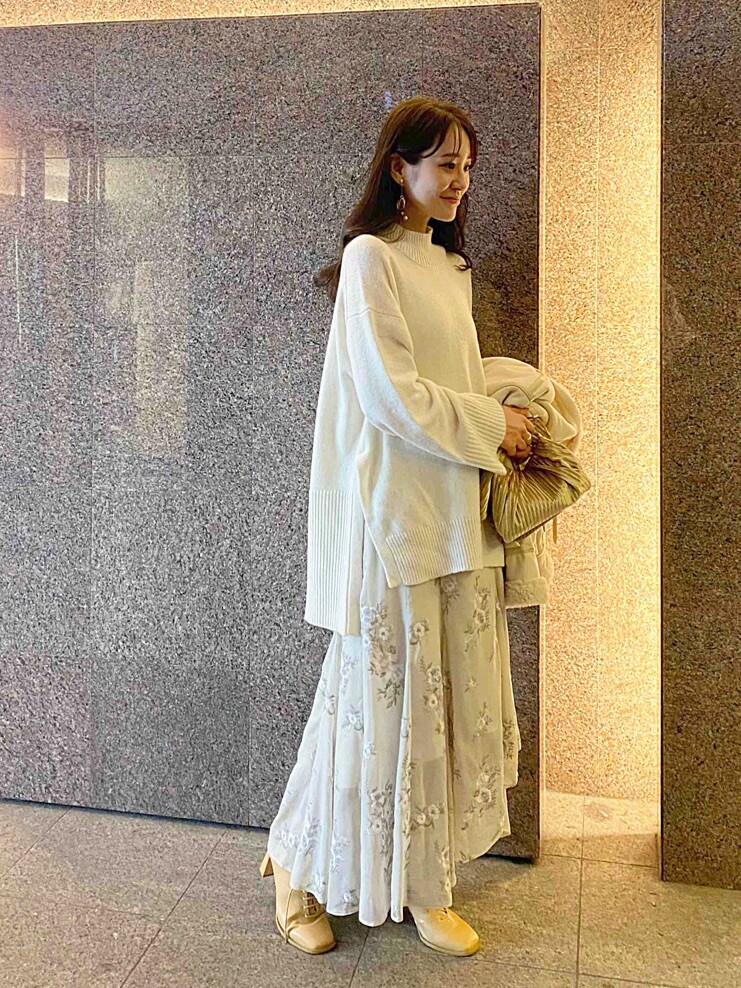 ベージュ系のクラッチバッグ、ホワイト系のムートンコート、ホワイト系のニット/セーターを着用したレディースの秋コーディネートの7枚目の写真