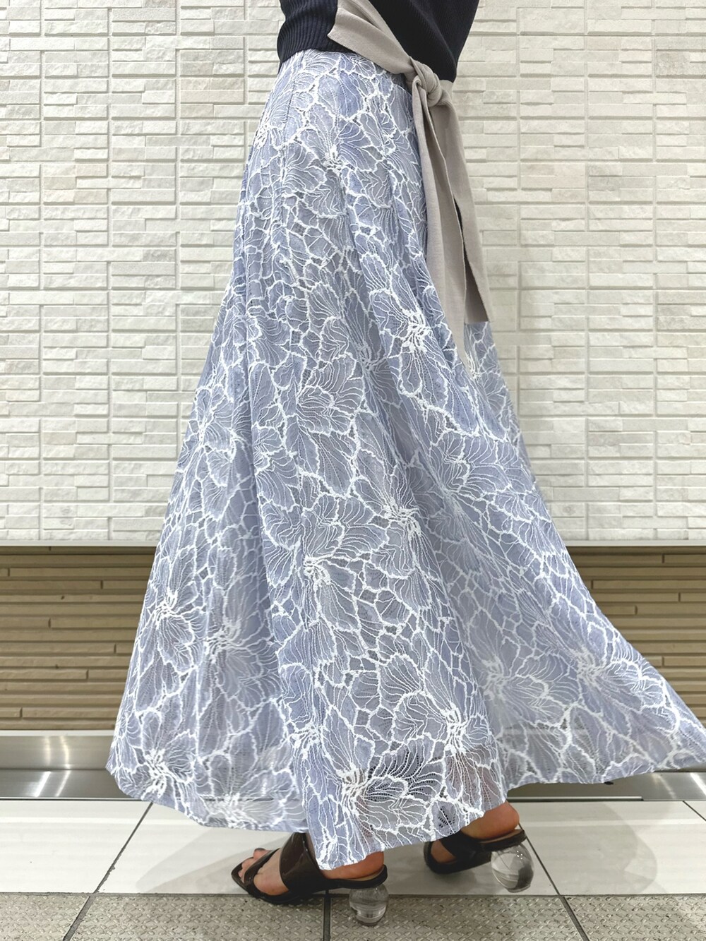 ブラック系のチューブトップ、ブルー系のスカート、ブラウン系のサンダルを着用したレディースの夏コーディネートの8枚目の写真