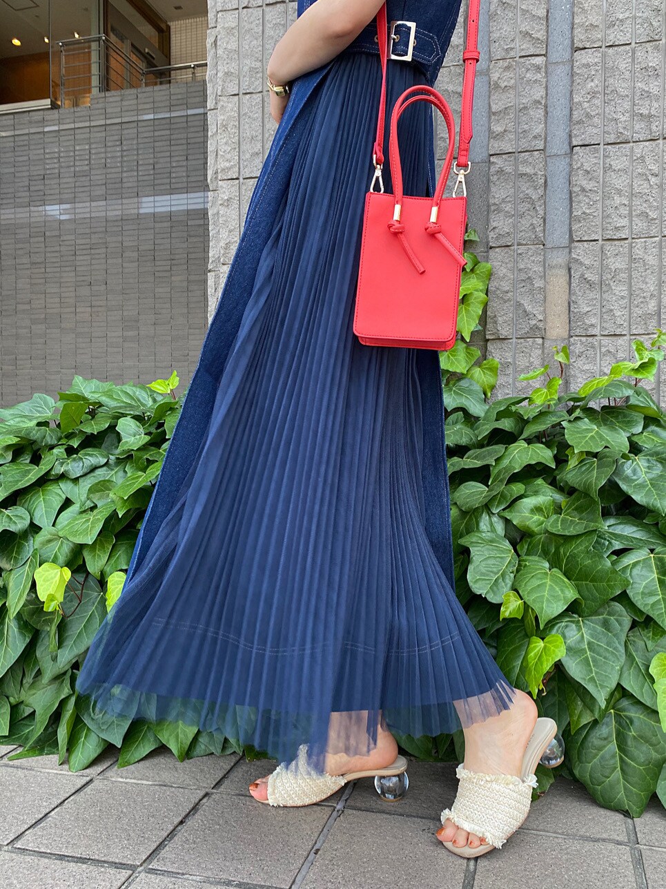 レッド系のハンドバッグ、ブルー系のワンピース、ホワイト系のニット/セーターを着用したレディースの夏コーディネートの8枚目の写真
