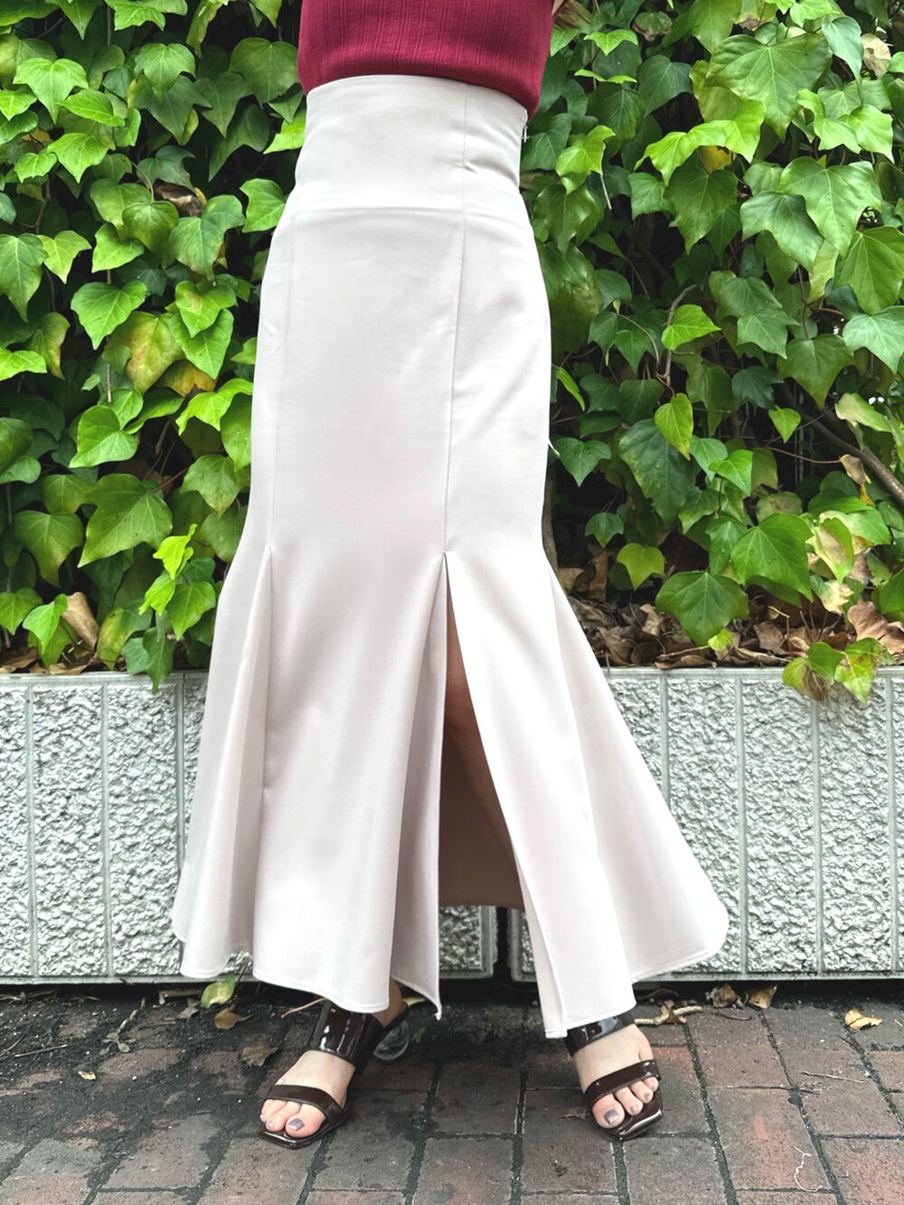 ブラウン系のサンダル、レッド系のニット/セーター、ピンク系のスカートを着用したレディースの夏コーディネートの6枚目の写真