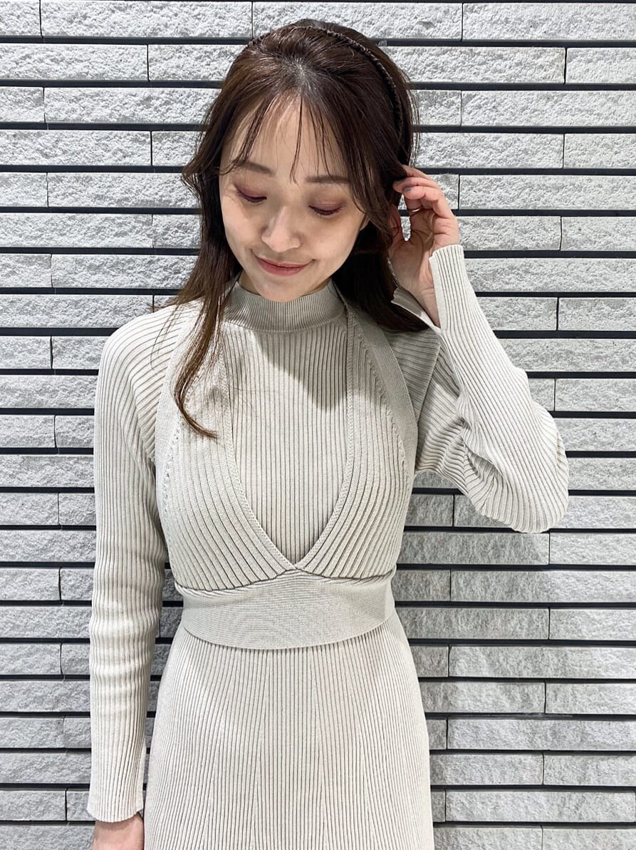 イエロー系のショルダーバッグ、ベージュ系のワンピース、ホワイト系のその他シューズを着用したレディースの冬コーディネートの5枚目の写真