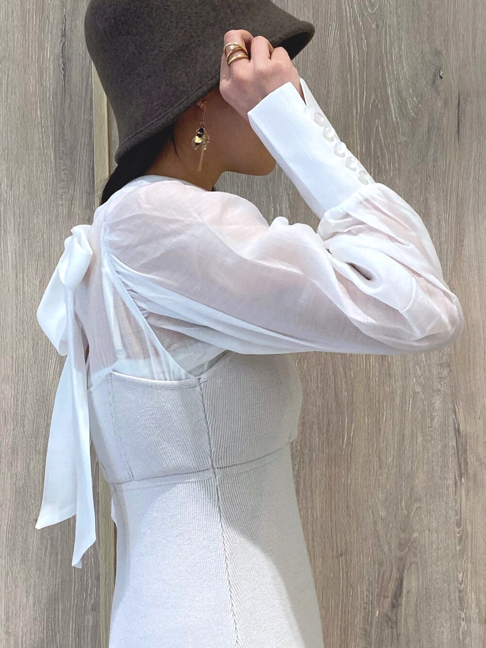 ベージュ系のブーツ、ホワイト系のワンピース、ホワイト系のチューブトップを着用したレディースの冬コーディネートの7枚目の写真