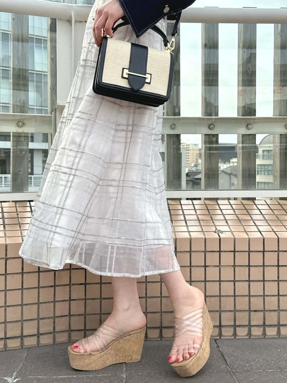 ホワイト系のハンドバッグ、グリーン系のワンピース、ブルー系のデニムジャケットを着用したレディースの春コーディネートの9枚目の写真