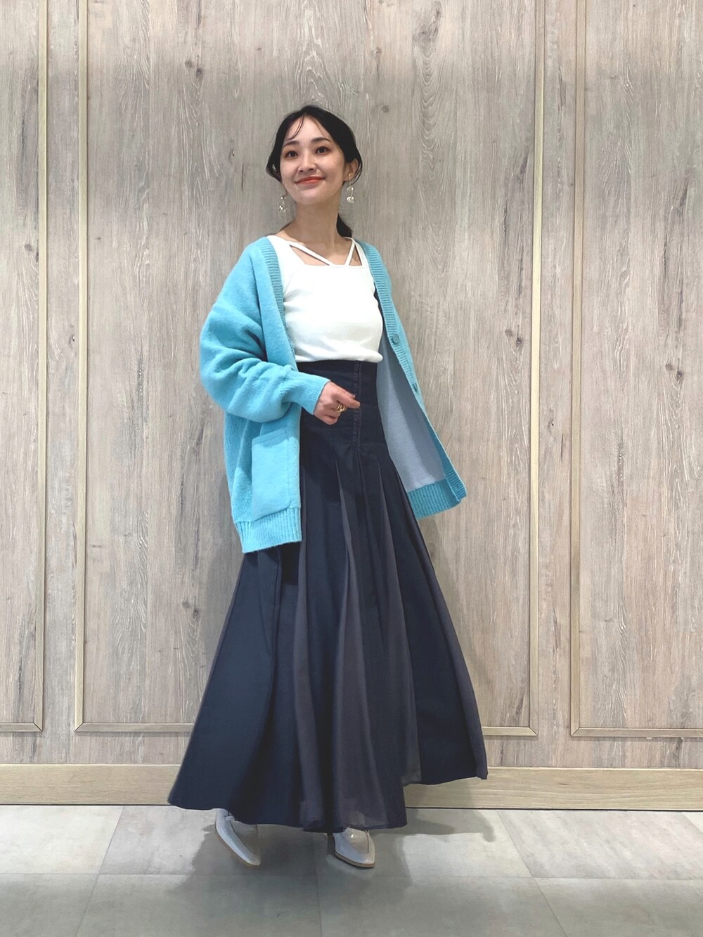 ホワイト系のローファー、グレー系のスカート、グリーン系のカーディガン/ボレロを着用したレディースの冬コーディネートの2枚目の写真