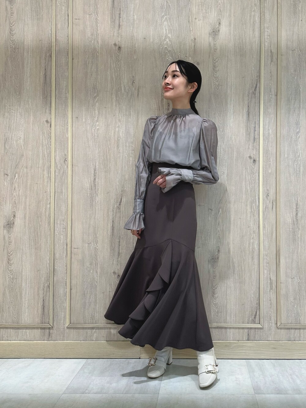 ホワイト系のブーツ、グレー系のシャツ/ブラウス、ブラウン系のスカートを着用したレディースの冬コーディネートの3枚目の写真