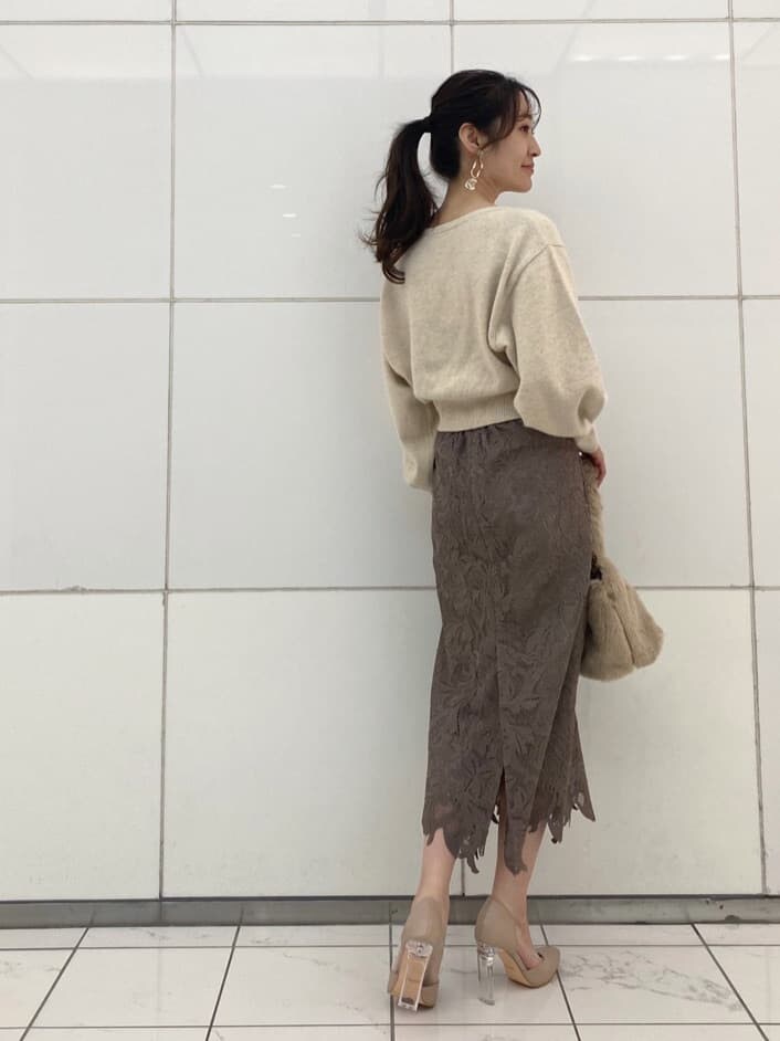 ベージュ系のパンプス、パープル系のチェスターコート、ホワイト系のニット/セーターを着用したレディースの冬コーディネートの9枚目の写真