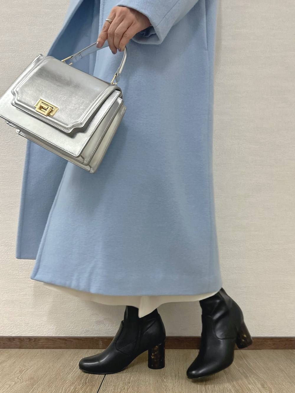 ブラック系のブーツ、シルバー系のハンドバッグ、ホワイト系のワンピースを着用したレディースの秋コーディネートの9枚目の写真