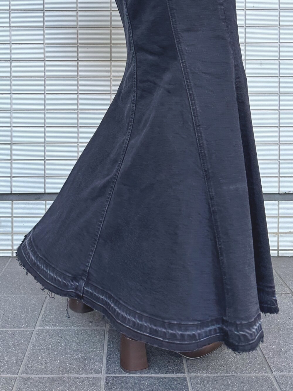 ブラウン系のニット/セーター、ブラック系のデニムスカート、ベージュ系のショルダーバッグを着用したレディースの秋コーディネートの8枚目の写真