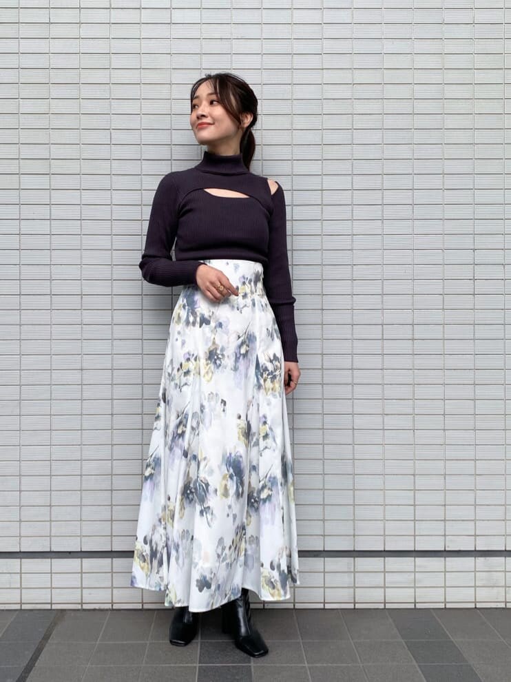 ブラック系のブーツ、グレー系のニット/セーター、ホワイト系のスカートを着用したレディースの秋コーディネートの2枚目の写真