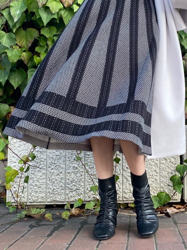 ブラック系のワンピース、ブラック系のその他シューズ、パープル系のステンカラーコートを着用したレディースの冬コーディネートの6枚目の写真