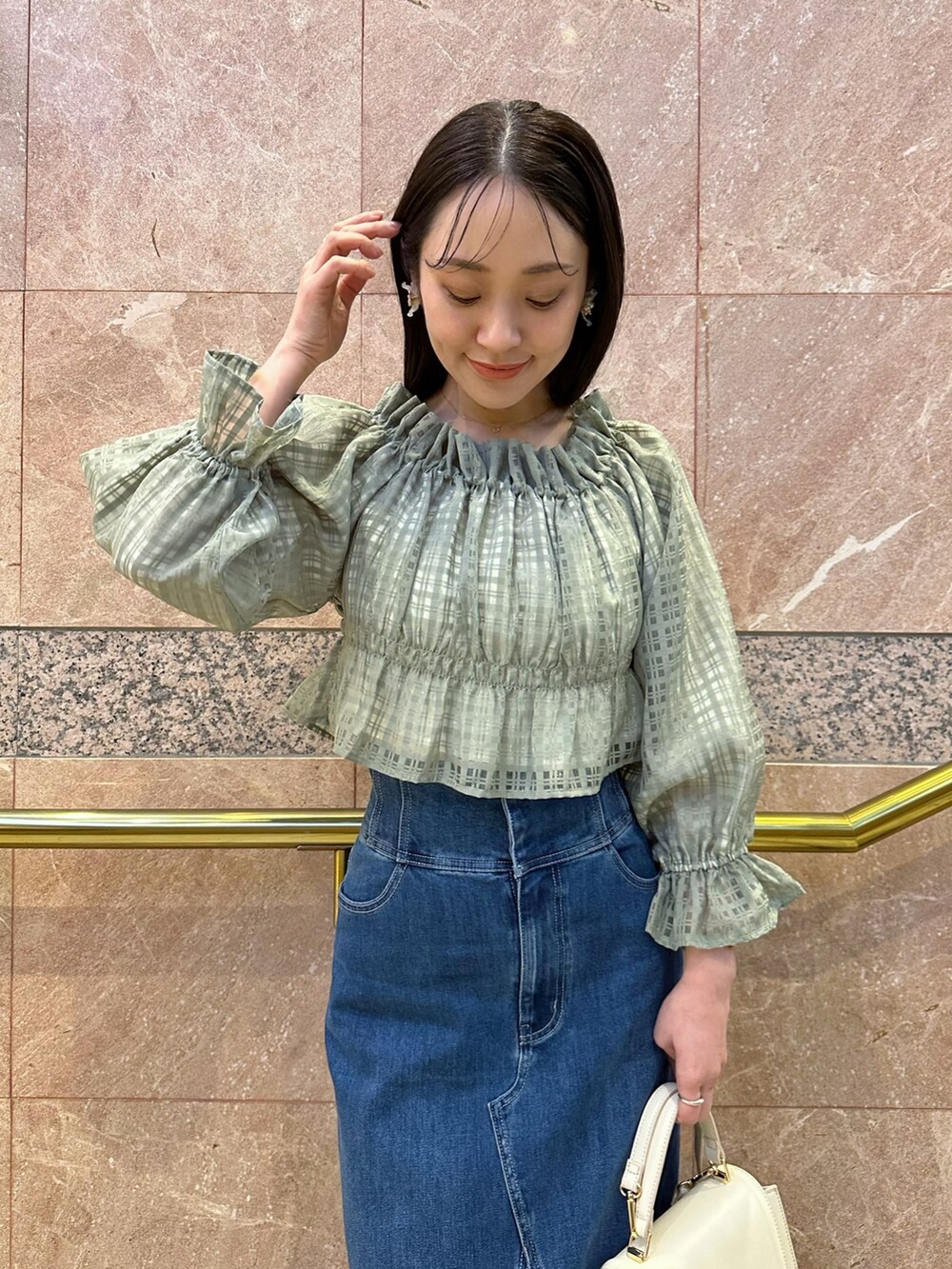 グリーン系のシャツ/ブラウス、ブルー系のデニムスカート、ベージュ系のパンプスを着用したレディースの冬コーディネートの8枚目の写真