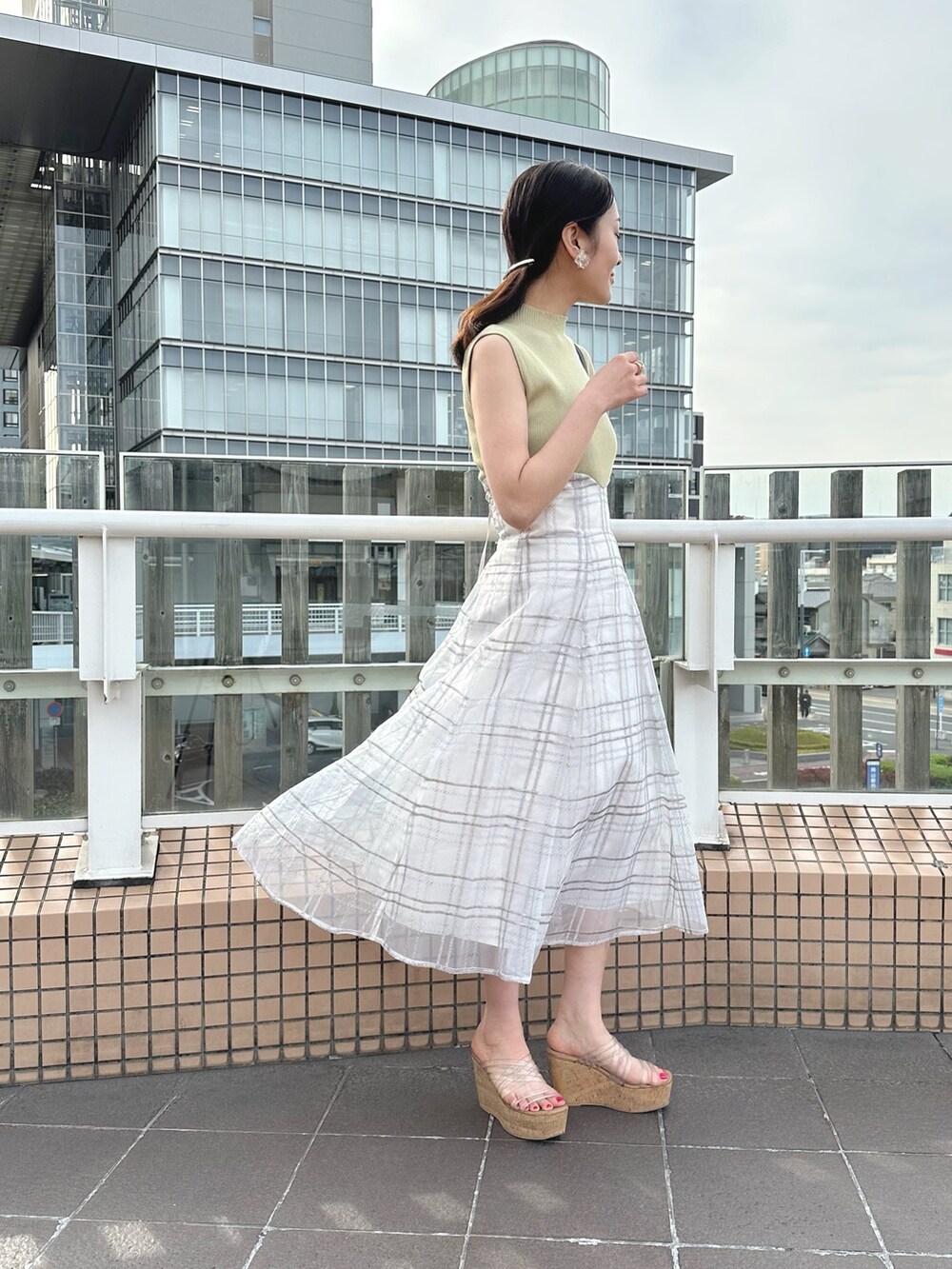 その他のサンダル、ブラック系のハンドバッグ、グリーン系のワンピースを着用したレディースの春コーディネートの3枚目の写真