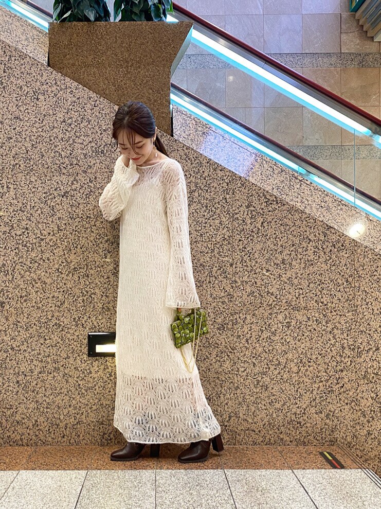 グリーン系のハンドバッグ、ホワイト系のワンピースを着用したレディースの秋コーディネートの2枚目の写真