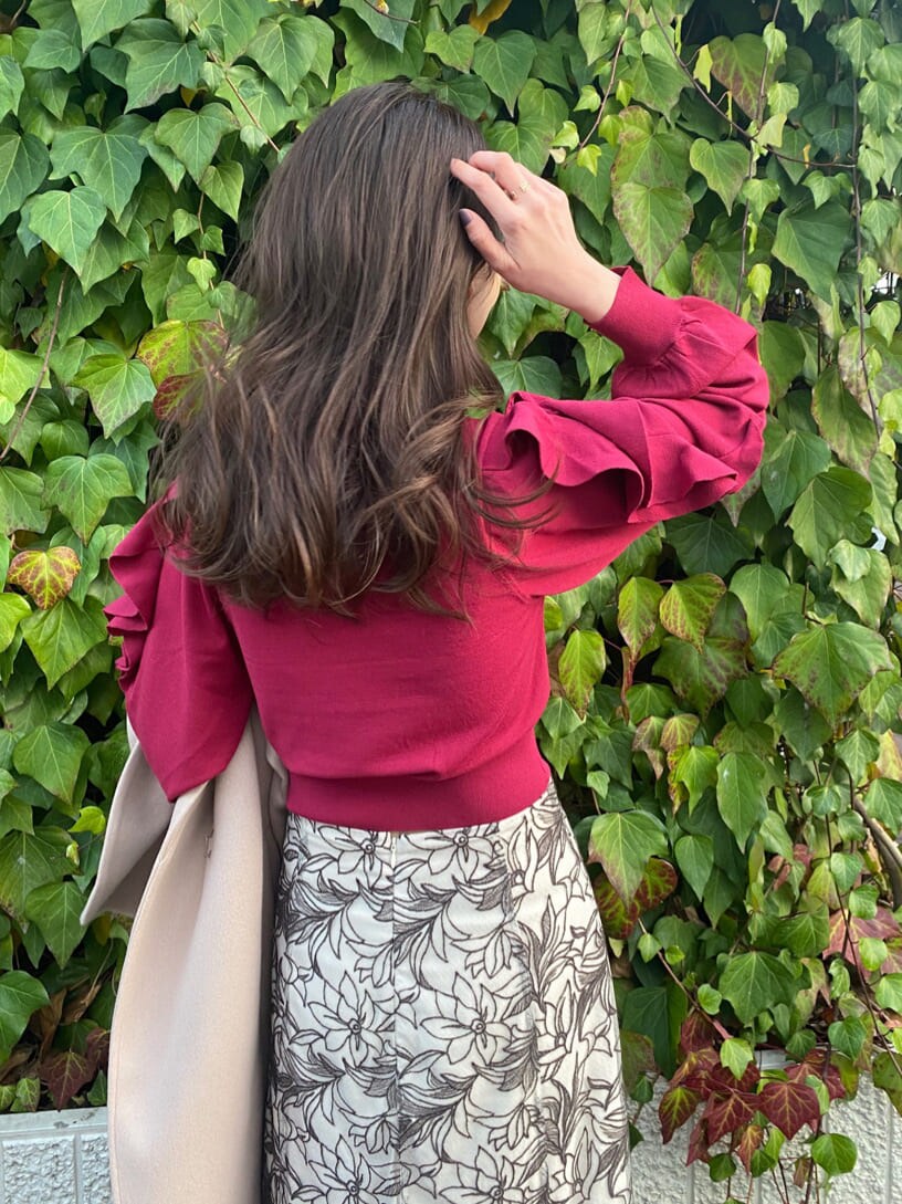 ブラウン系のその他シューズ、ベージュ系のステンカラーコート、レッド系のニット/セーターを着用したレディースの冬コーディネートの4枚目の写真