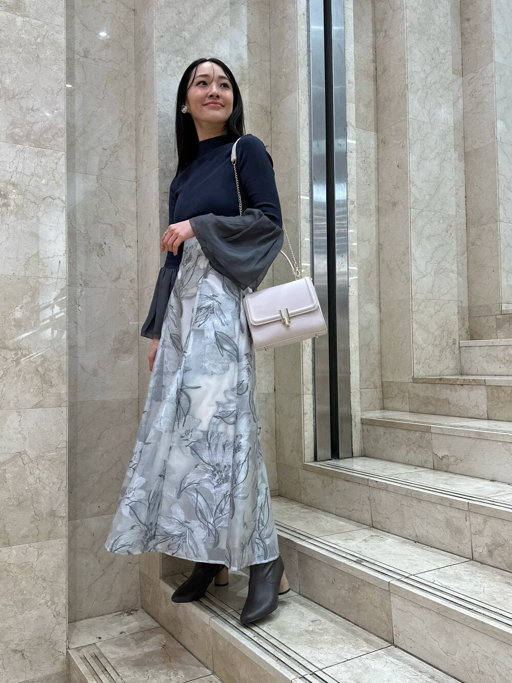 ブラウン系のブーツ、ピンク系のショルダーバッグ、グレー系のニット/セーターを着用したレディースの春コーディネートの2枚目の写真