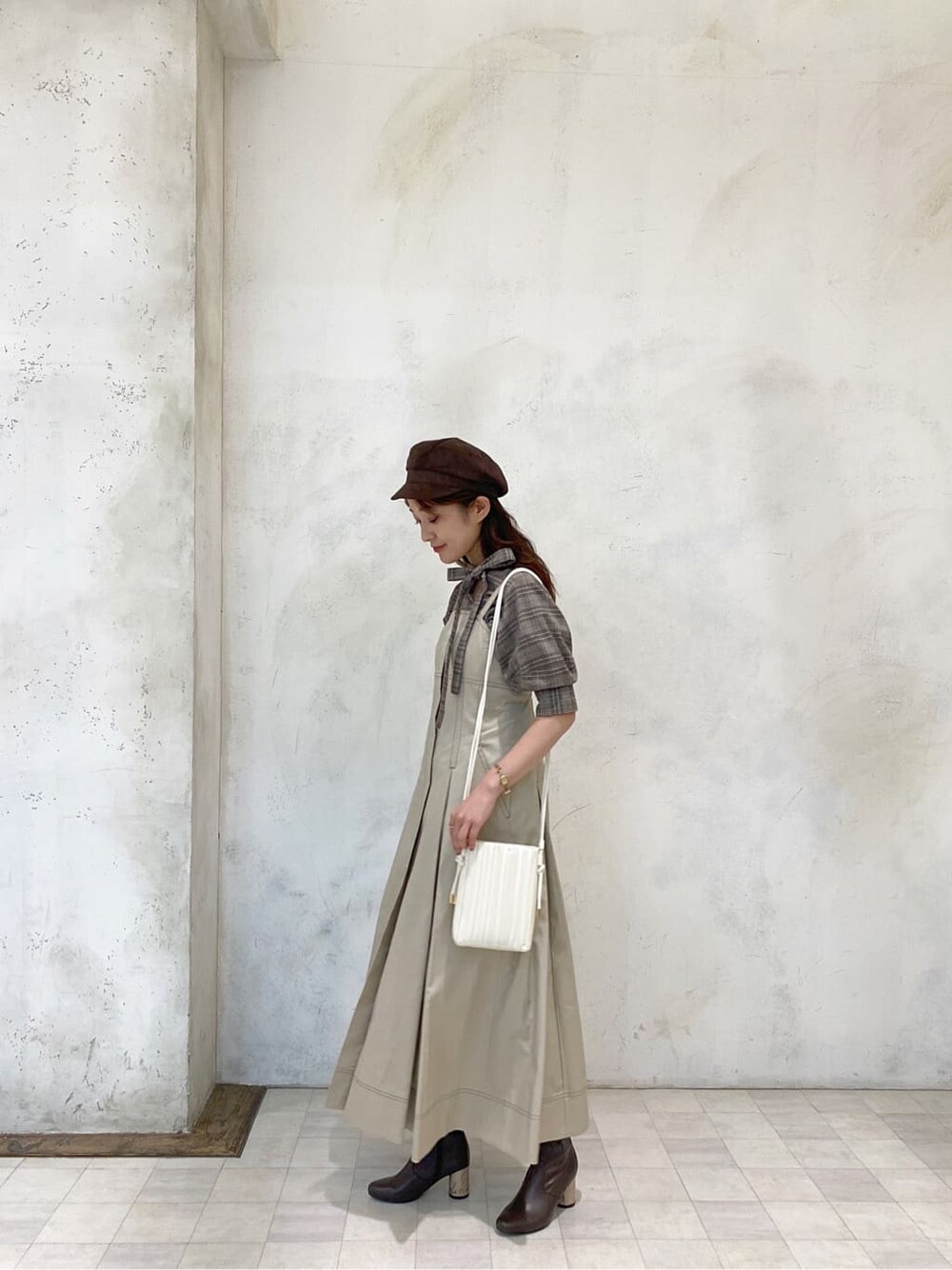 ベージュ系のワンピース、ブラウン系のその他シューズ、ホワイト系のハンドバッグを着用したレディースの夏コーディネートの2枚目の写真