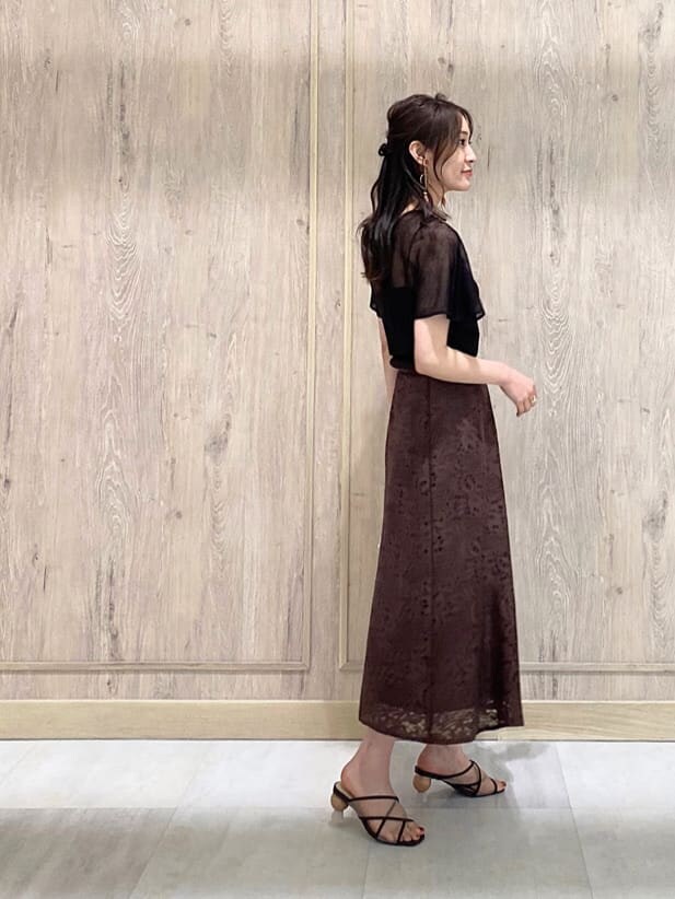 ホワイト系のハンドバッグ、ブラウン系のスカート、ブラウン系のニット/セーターを着用したレディースの夏コーディネートの3枚目の写真