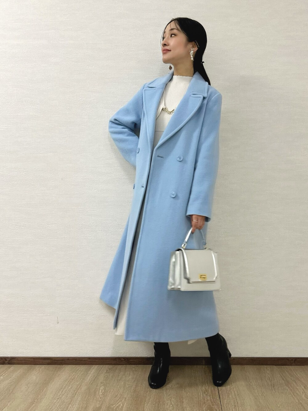 ブラック系のブーツ、シルバー系のハンドバッグ、ホワイト系のワンピースを着用したレディースの秋コーディネートの3枚目の写真