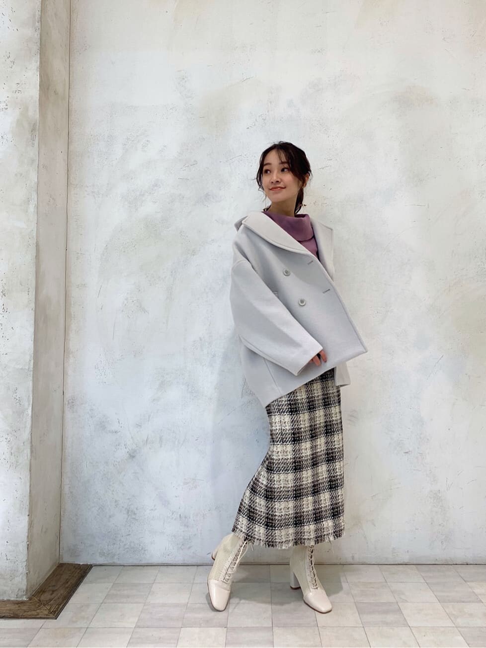 グリーン系のブルゾン、ピンク系のニット/セーター、ホワイト系のブーツを着用したレディースの秋コーディネートの2枚目の写真