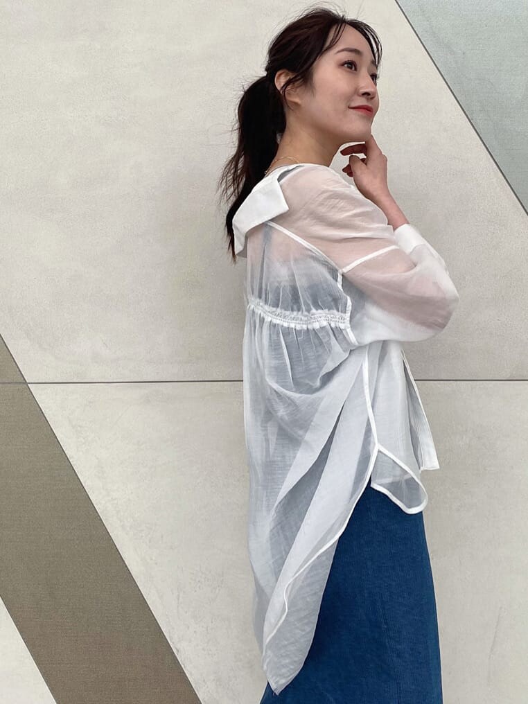 イエロー系のショルダーバッグ、ブルー系のジャンパースカート、ベージュ系のキャミソールを着用したレディースの春コーディネートの4枚目の写真