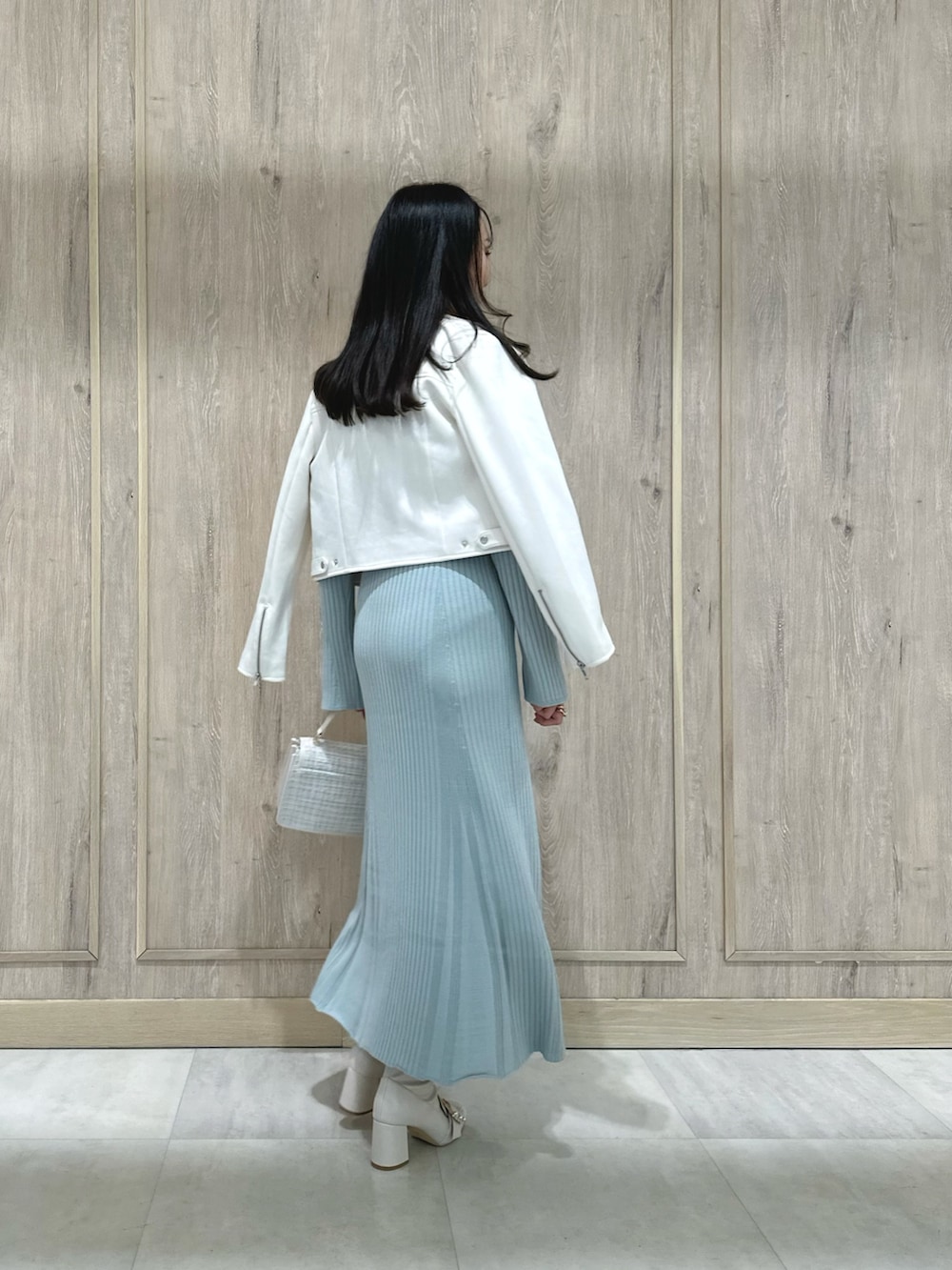 ホワイト系のハンドバッグ、ホワイト系のブーツ、ブルー系のワンピースを着用したレディースの冬コーディネートの4枚目の写真