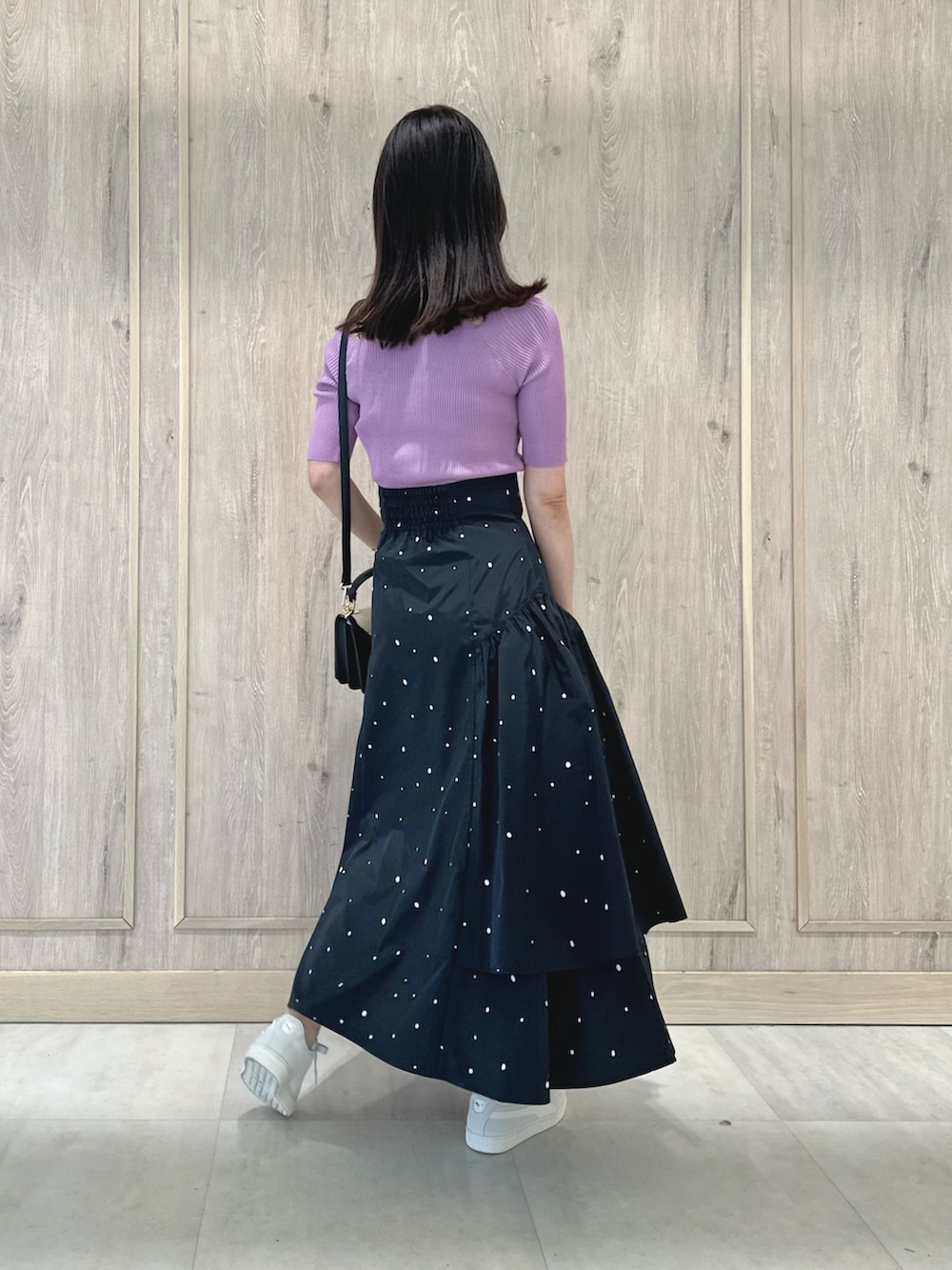 ピンク系のニット/セーター、その他のスカート、ブラック系のハンドバッグを着用したレディースの春コーディネートの3枚目の写真