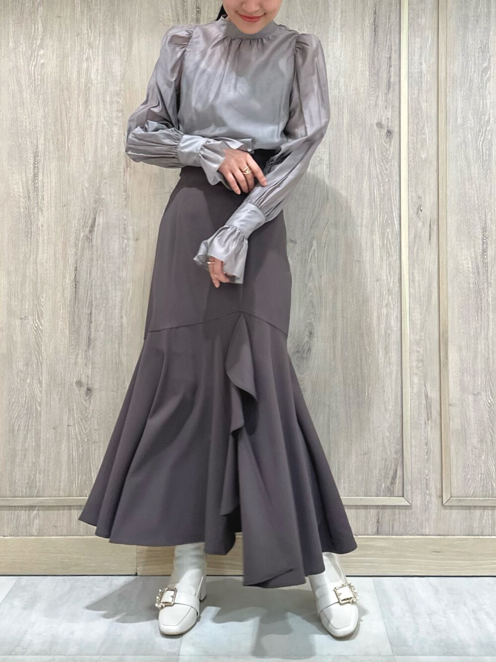 ホワイト系のブーツ、グレー系のシャツ/ブラウス、ブラウン系のスカートを着用したレディースの冬コーディネートの2枚目の写真