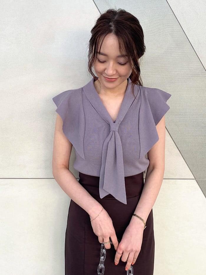 ピンク系のショルダーバッグ、グレー系のニット/セーター、ブラウン系のスカートを着用したレディースの春コーディネートの3枚目の写真