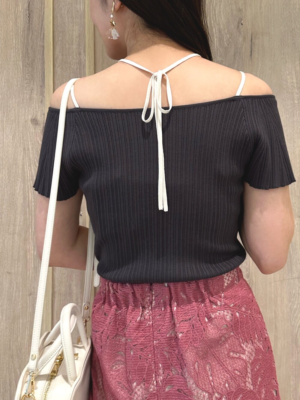 ホワイト系のハンドバッグ、グレー系のニット/セーター、ピンク系のスカートを着用したレディースの春コーディネートの6枚目の写真