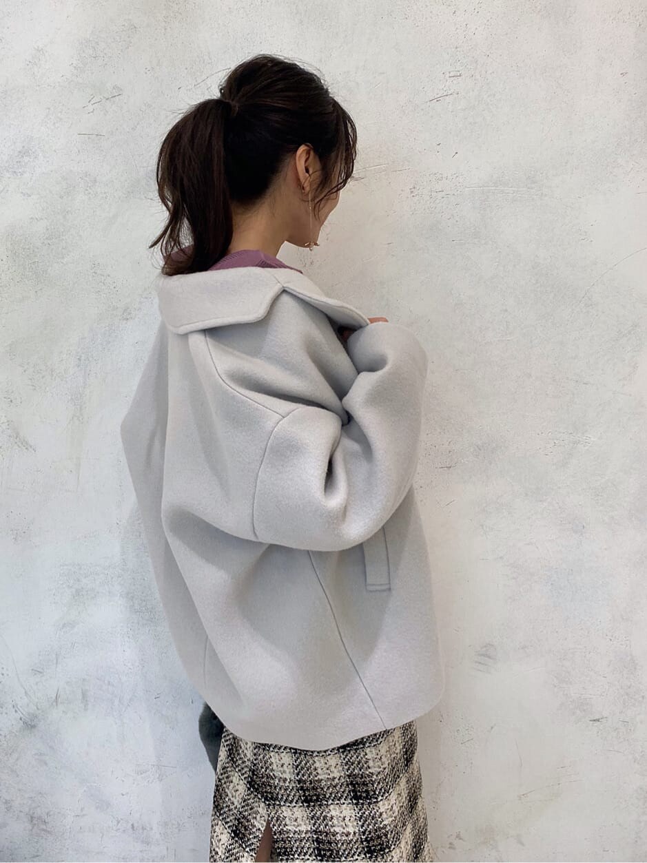 グリーン系のブルゾン、ピンク系のニット/セーター、ホワイト系のブーツを着用したレディースの秋コーディネートの4枚目の写真