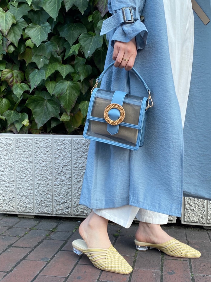 ブルー系のトレンチコート、イエロー系のサンダル、ホワイト系のその他パンツを着用したレディースの春コーディネートの2枚目の写真