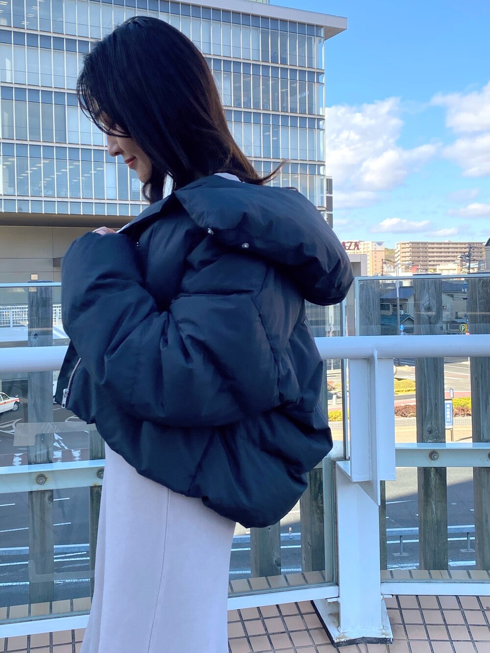 ブラック系のブーツ、ベージュ系のワンピース、ブラック系のダウンジャケット/コートを着用したレディースの冬コーディネートの6枚目の写真