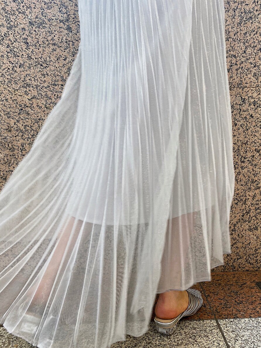 シルバー系のサンダル、シルバー系のスカート、ホワイト系のハンドバッグを着用したレディースの春コーディネートの4枚目の写真