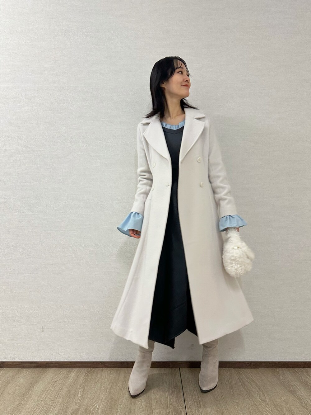 グレー系のブーツ、グレー系のニット/セーター、ブラック系のスカートを着用したレディースの冬コーディネートの2枚目の写真