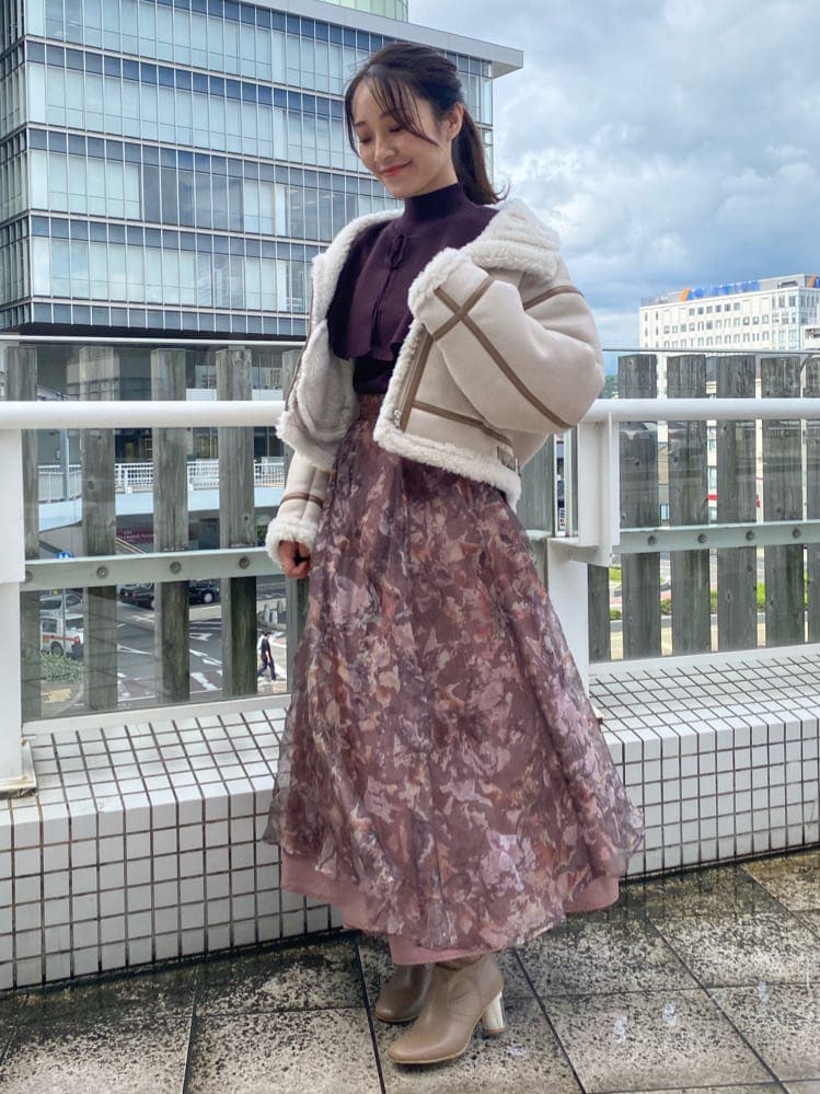 ベージュ系のブーツ、ベージュ系のムートンコート、ブラウン系のニット/セーターを着用したレディースの秋コーディネートの2枚目の写真