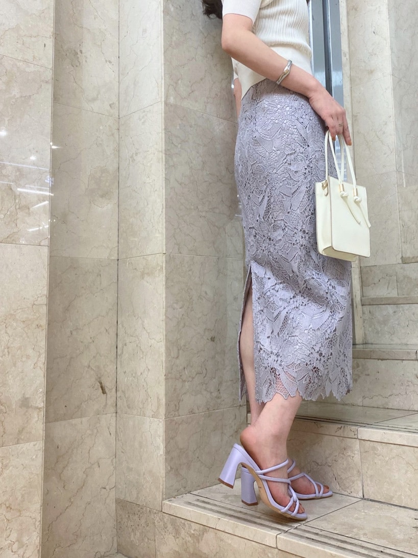 ホワイト系のハンドバッグ、パープル系のサンダル、パープル系のスカートを着用したレディースの春コーディネートの2枚目の写真