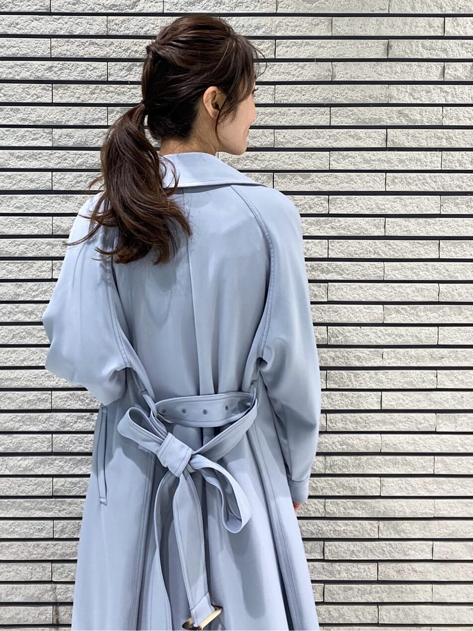 ブルー系のトレンチコート、ホワイト系のワンピース、ホワイト系のその他シューズを着用したレディースの冬コーディネートの5枚目の写真