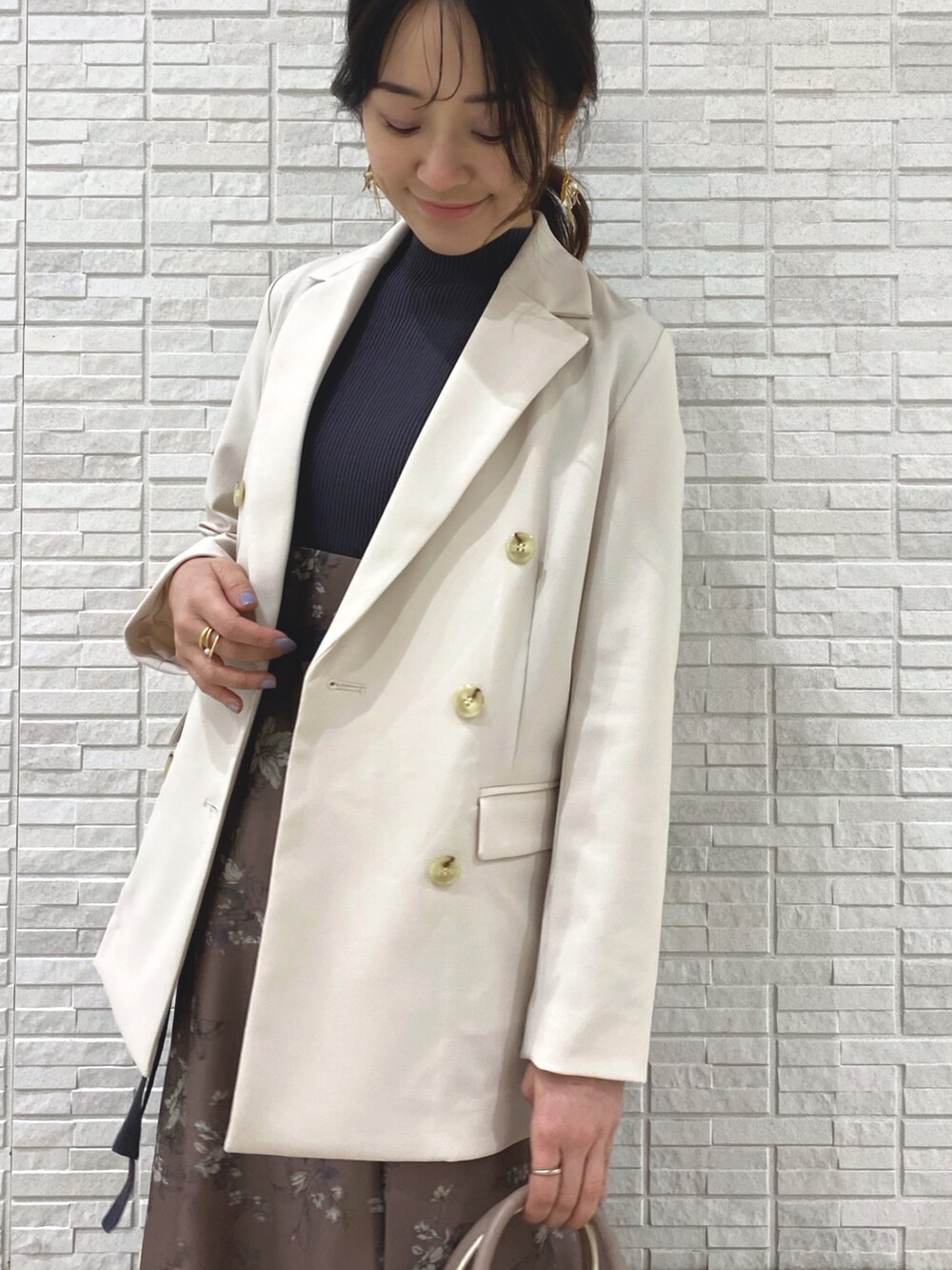 ベージュ系のブーツ、ホワイト系のテーラードジャケット、ベージュ系のハンドバッグを着用したレディースの冬コーディネートの5枚目の写真