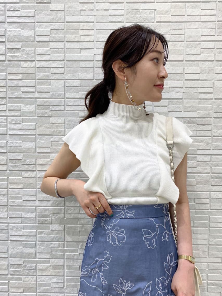 ホワイト系のショルダーバッグ、ブルー系のスカート、ホワイト系のニット/セーターを着用したレディースの夏コーディネートの2枚目の写真