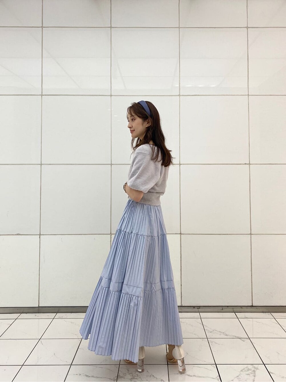 ブルー系のスカート、ベージュ系のハンドバッグ、ホワイト系のその他シューズを着用したレディースの夏コーディネートの3枚目の写真