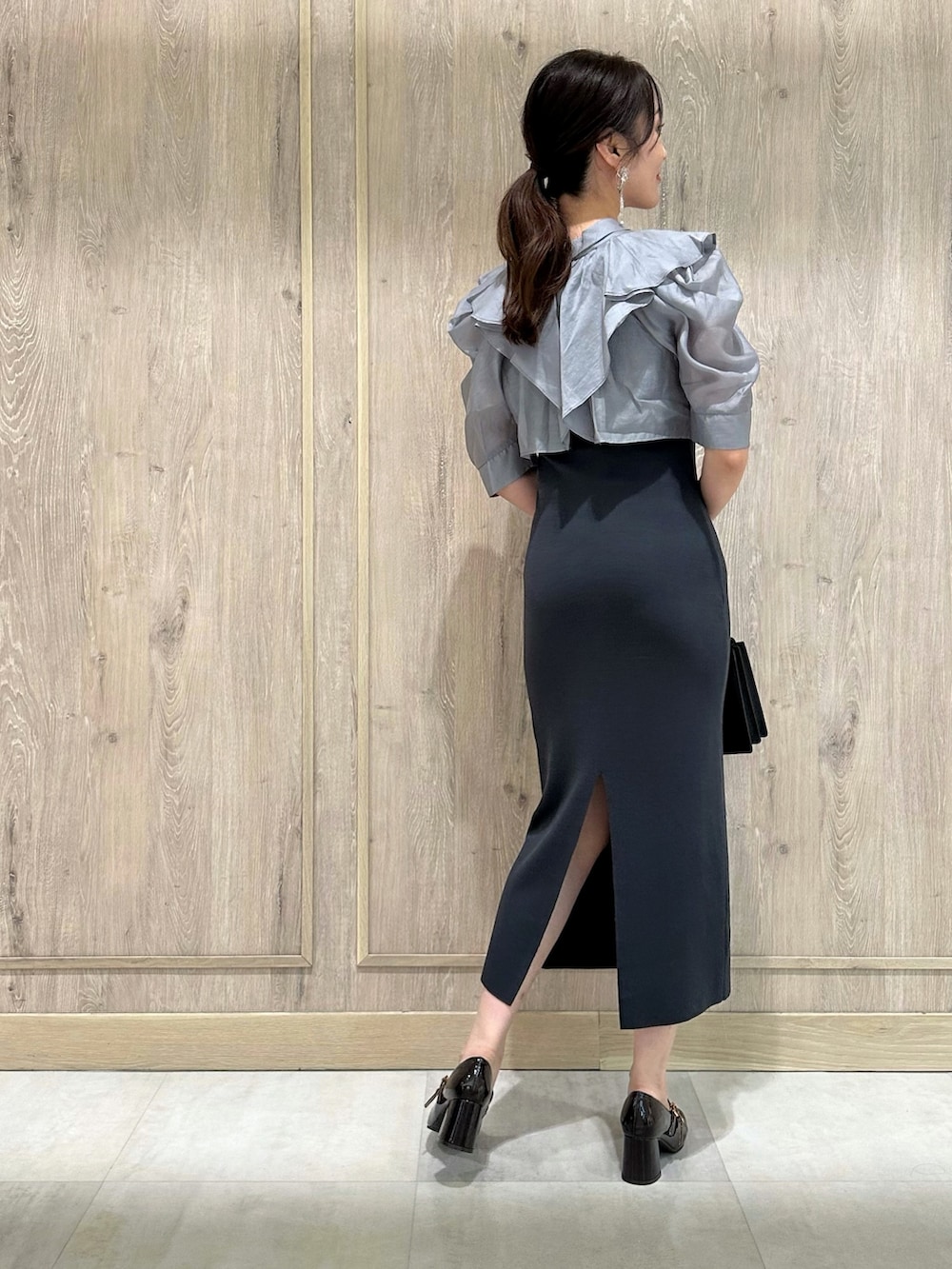 ブラウン系のパンプス、ブラック系のハンドバッグ、グレー系のワンピースを着用したレディースの夏コーディネートの3枚目の写真