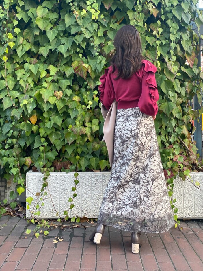 ブラウン系のその他シューズ、ベージュ系のステンカラーコート、レッド系のニット/セーターを着用したレディースの冬コーディネートの5枚目の写真