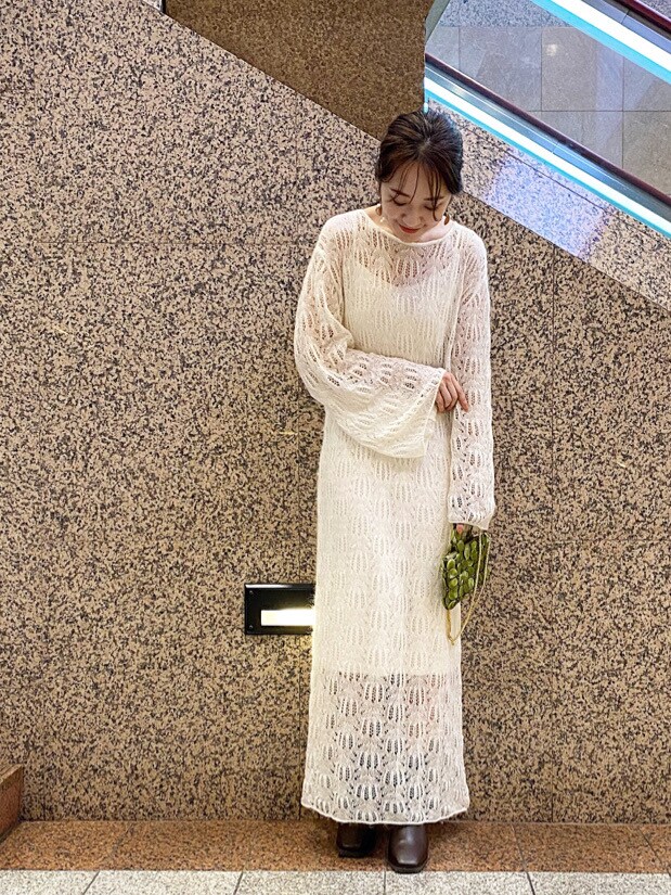 グリーン系のハンドバッグ、ホワイト系のワンピースを着用したレディースの秋コーディネートの3枚目の写真