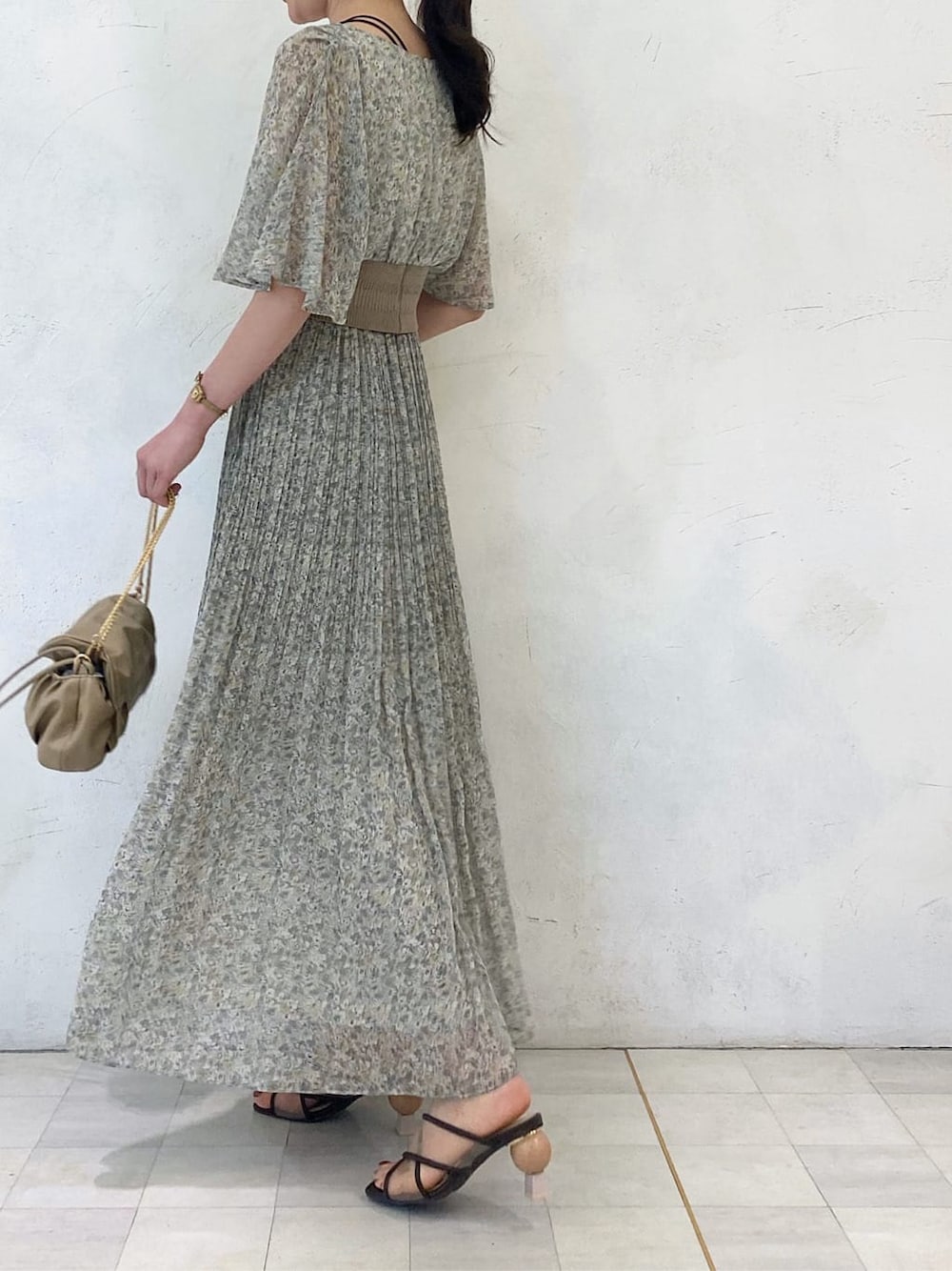 グリーン系のシャツ/ブラウス、ベージュ系のクラッチバッグ、グリーン系のスカートを着用したレディースの夏コーディネートの3枚目の写真