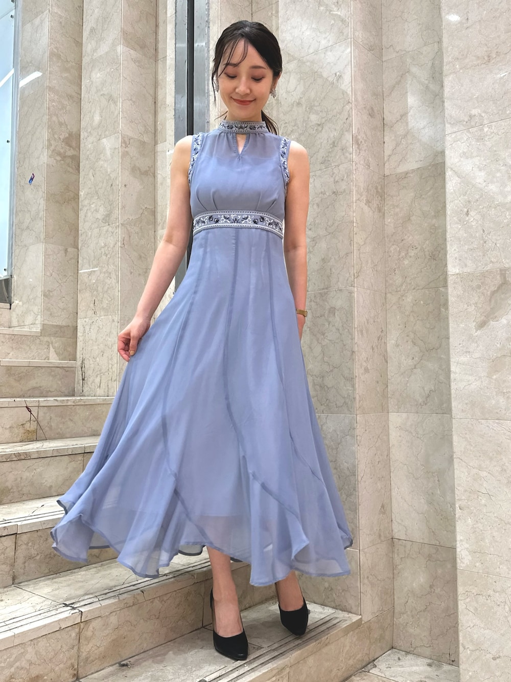 ブラック系のパンプス、ブルー系のドレス、シルバー系のイヤリングを着用したレディースの夏コーディネートの2枚目の写真