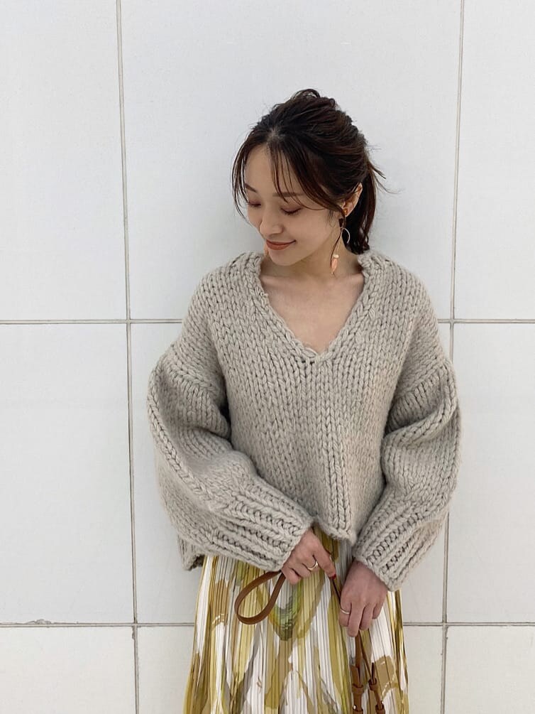 イエロー系のスカート、グレー系のニット/セーター、ベージュ系のブーツを着用したレディースの秋コーディネートの6枚目の写真