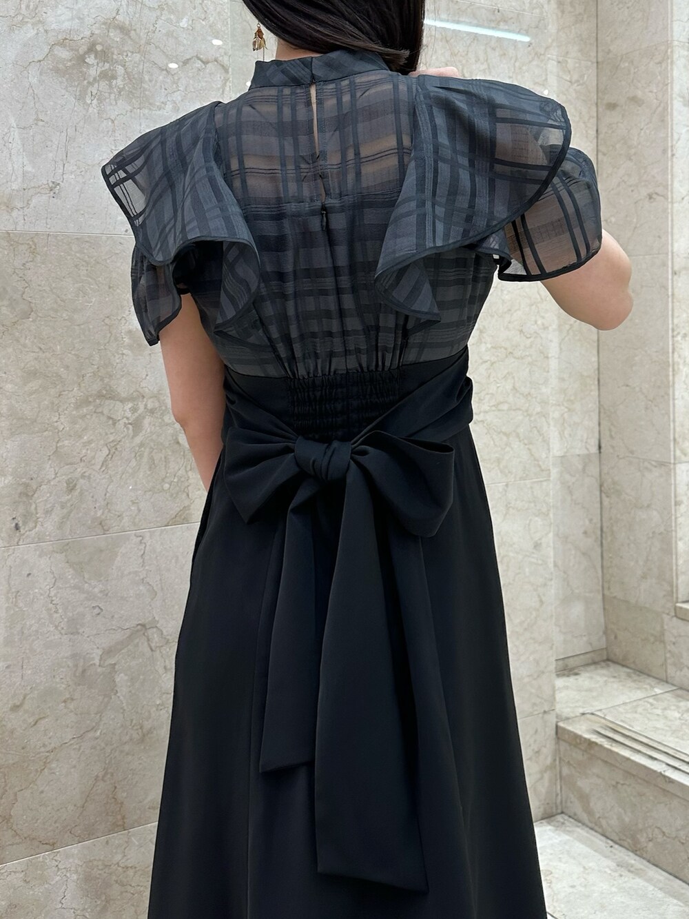 ブラック系のワンピース、ブルー系のハンドバッグ、その他のサンダルを着用したレディースの春コーディネートの7枚目の写真