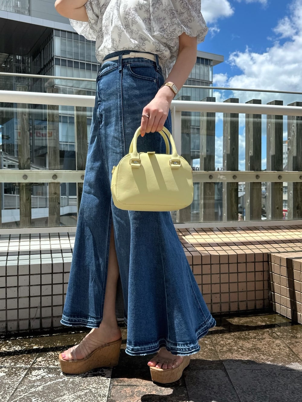 その他のサンダル、ブルー系のデニムスカート、グレー系のシャツ/ブラウスを着用したレディースの夏コーディネートの8枚目の写真