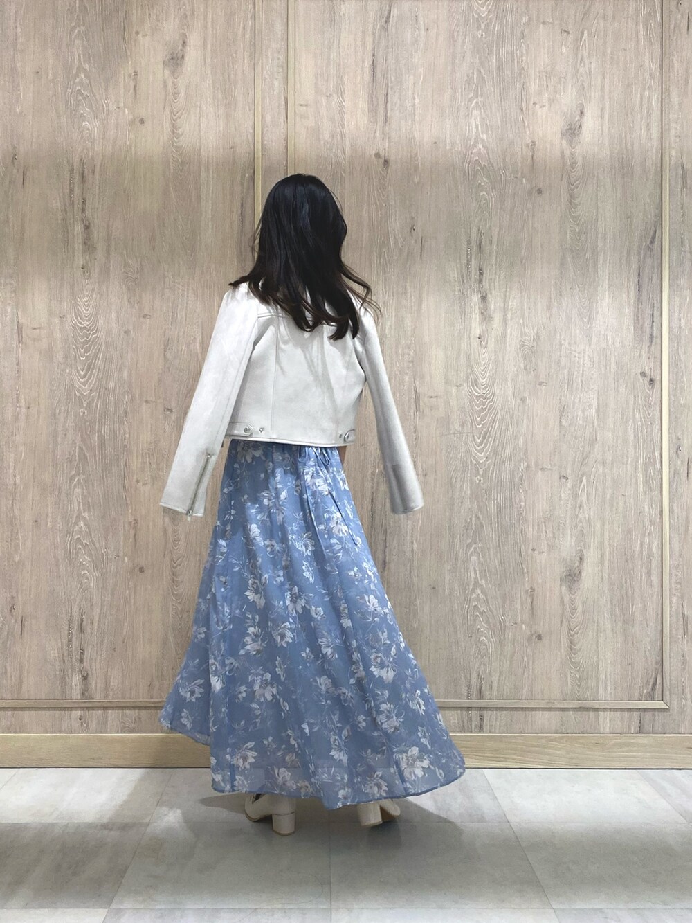 ブルー系のワンピース、ピンク系のライダースジャケット、ホワイト系のローファーを着用したレディースの冬コーディネートの4枚目の写真