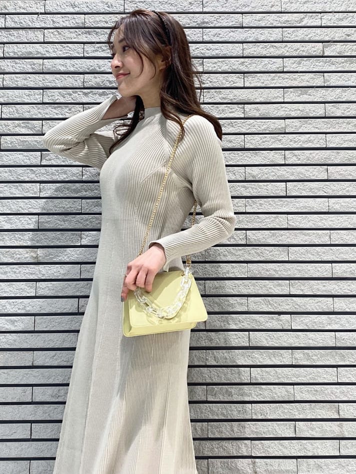 イエロー系のショルダーバッグ、ベージュ系のワンピース、ホワイト系のその他シューズを着用したレディースの冬コーディネートの7枚目の写真